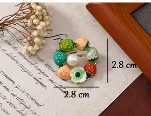 Detailed view of strawberry wreath brooch with enamel fruits and pearl, size 2.8cm x 2.8cm