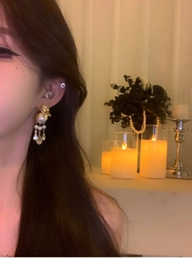 Détail de boucles d'oreilles vintage en perles dorées avec cristaux goutte d'eau sur modèle
