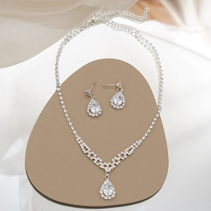 Detailed view of silver bridal jewelry set with pear-cut cubic zirconia on stone props