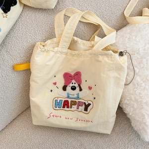 Detail of cute puppy towel embroidery and drawstring closure on beige tote bag