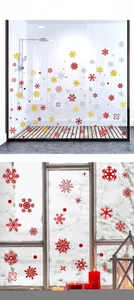Close-up of glittery red, gold, and silver snowflake window stickers for holiday decor
