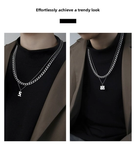 Detail of silver double layer necklace with gothic letter pendants and cuban chain links
