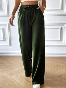 Detail of high waist drawstring and ribbed texture on dark green wide leg pants