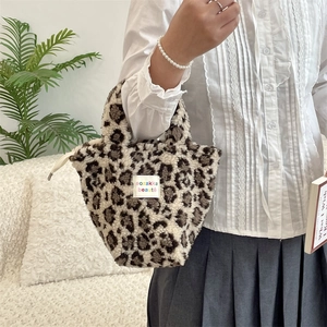Detail of plush leopard print tote bag with white branded label and soft faux fur texture