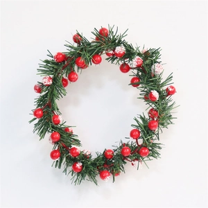 Close-up of artificial pine needles and red berries with snow for Christmas wreath
