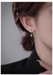 Macro shot of 925 silver flower drop earrings with sparkling cubic zirconia on model