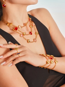 Primer plano de modelo con conjunto de collar y pulsera de corazón con piedras rosas