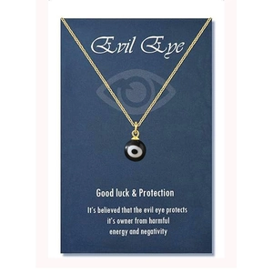 Close-up of a gold-plated evil eye pendant necklace on a blue gift display card