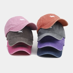 Détail de casquettes en coton lavé coloré avec logo brodé de chien de style vintage