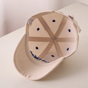 Detail view of cotton baseball cap interior showing 100% cotton label and blue embroidery