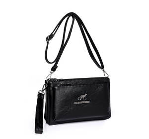 Vista de detalle de bolso bandolera negro multicapa de cuero con logo de canguro plata