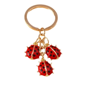 Golden keychain featuring three cute red ladybug charms with black spots for bags