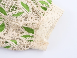 Détail macro du tissu en dentelle au crochet vert et beige avec motif tricoté ajouré