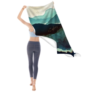 Microfiber beach towel featuring a blue mountain landscape print held by a model