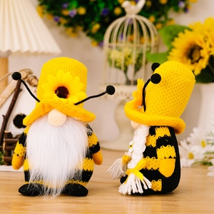 Nahaufnahme von handgefertigten Bienen-Gnom-Puppen mit Sonnenblumen und Strickmützen