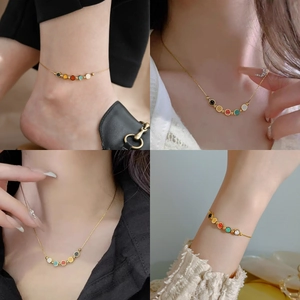 Detailed view of colorful smiley charms on an 18k gold plated stainless steel anklet chain