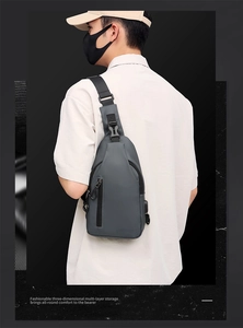 Detail view of dark grey men's chest bag showing the USB charging port and zipper