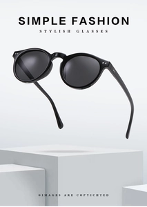 Close-up of black round sunglasses on white geometric stand with blue light blocking lenses