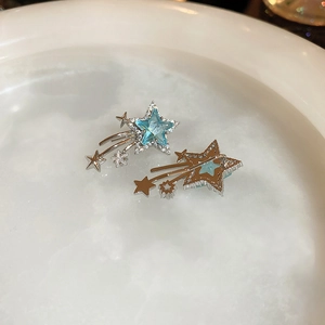 Macro shot of silver star stud earrings with light blue zircon stones in a white tray