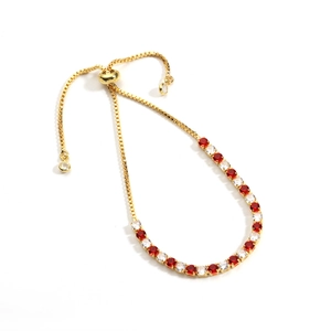 Detailed view of adjustable gold bolo bracelet with sparkling red and white round zircon