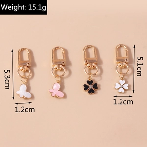Detailed view of enamel butterfly and clover keychains with size and weight dimensions