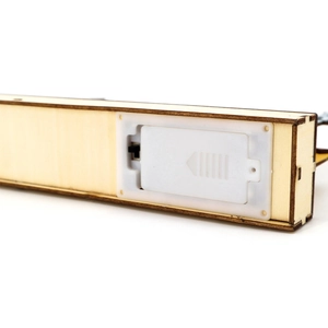 Close-up of wooden base featuring battery compartment and black power switch