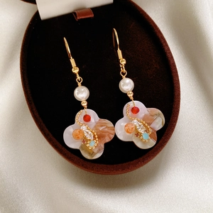 Detailed shot of vintage floral earrings with marble texture and colorful zircon in jewelry box