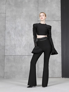 Détail du haut noir en dentelle à manches longues ajourées avec pantalon évasé assorti