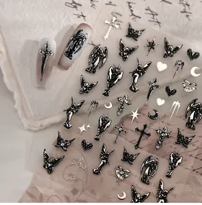 Detail of gothic black embossed nail stickers featuring angels and crosses on sheet