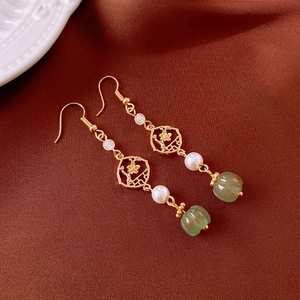 Detail of vintage Chinese earrings with plum blossom motifs and light green pumpkin beads
