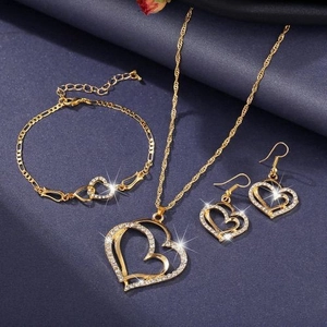 Detail of gold jewelry set with hollow heart-shaped pendants and micro-pave diamonds