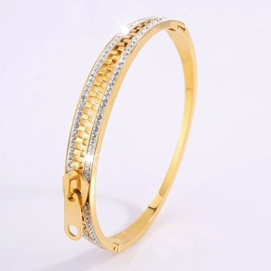 Detail of gold-plated zipper bangle with sparkling white cubic zirconia stones