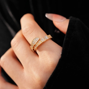Detail of gold snake-shaped ring featuring textured scales and zircon pavé setting