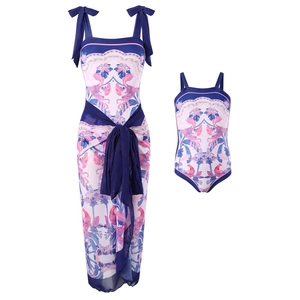 Detail of floral and bird print on matching parent-child swimsuit set and sarong