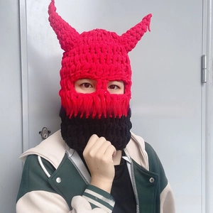Detail of hand-knitted balaclava with red devil horns and bold black contrast