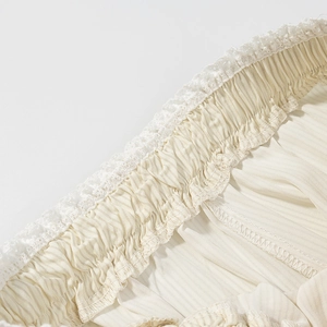 Détail de la taille élastique crème avec bordure en dentelle et texture de tissu plissé