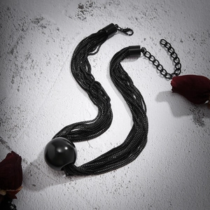 Detail view of multi-layer black punk chain necklace with large spherical ball pendant
