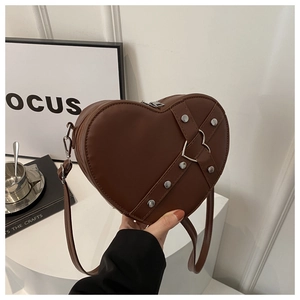 Détail du sac marron en forme de cœur avec rivets argentés et boucle en métal sur similicuir