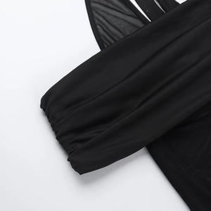 Detailaufnahme des schulterfreien Kleides mit schwarzen Netzeinsätzen und Stoffstruktur