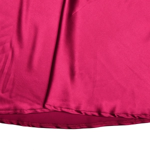 Détail de l'ourlet de la robe en satin fuchsia montrant la double couche et la couture fine