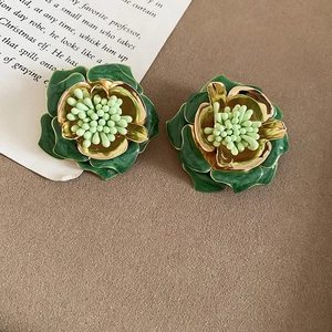 Vue détaillée de la boucle d'oreille fleur en émail vert rétro avec dorure élégante