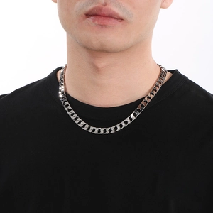 Polished silver cuban chain necklace displayed on male model's neck with black shirt