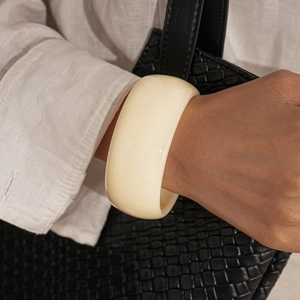Close-up of cream acrylic bangle on wrist with elegant vintage marbled texture