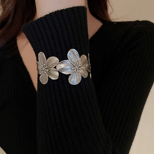 Close-up of vintage silver floral cuff bracelet featuring detailed textured metal petals