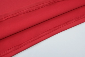 Nahaufnahme von rotem Stoff mit professionellem Doppel-Nadel-Stich-Detail