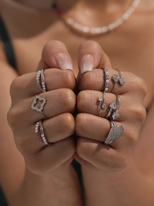 Detail shot of silver-colored rings featuring pearl and cubic zirconia floral accents