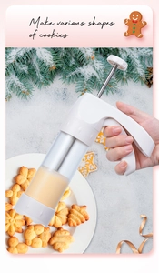 Macro view of clear cookie press gun making various biscuit shapes on snowy background