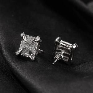 Detailed view of silver dragon claw stud earrings with square cubic zirconia on black silk