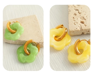 Detail of flower dangle earrings in green and yellow resin with gold hoops