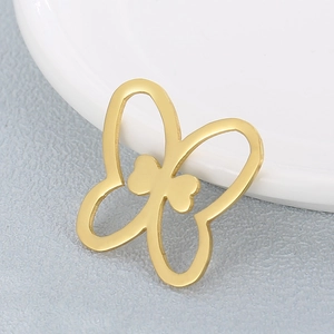 Minimalist gold butterfly pendant with hollow design on grey textured background